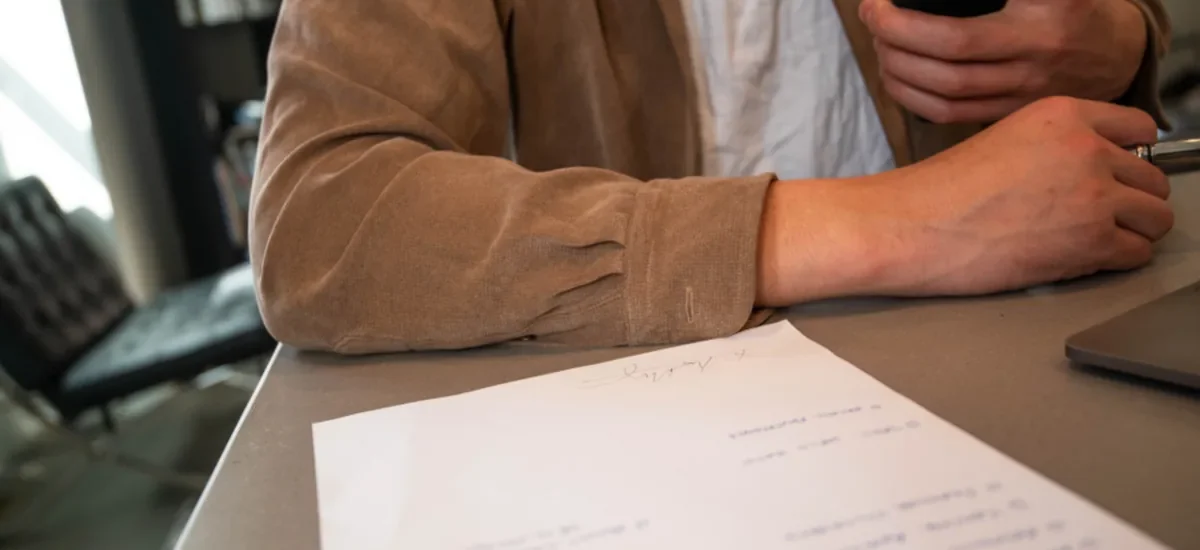 Business owner at a desk with a signed document, checking business loan requirements