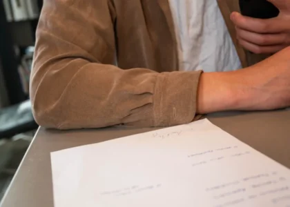 Business owner at a desk with a signed document, checking business loan requirements