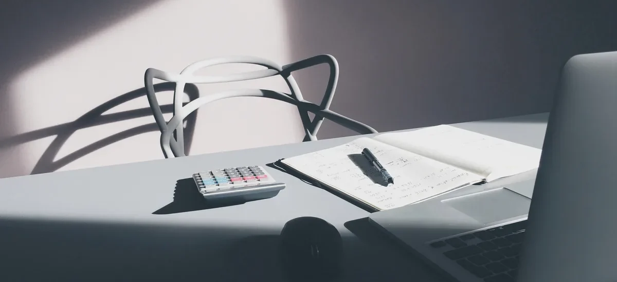 Desk with a laptop, calculator and notebook for checking line of credit requirements