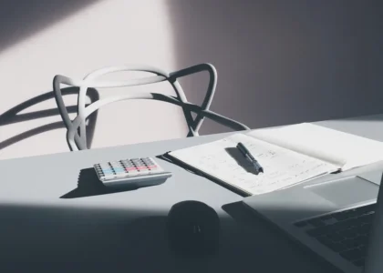 Desk with a laptop, calculator and notebook for checking line of credit requirements